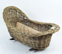 A vintage wicker dolls' crib, supported on rockers,