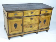 A substantial stained pine storage unit, the central section comprised of three drawers,