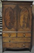 A mahogany linen press, the two doors with oval inset panels above two short and two long drawers,