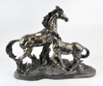 A large contemporary bronzed horse sculpture depicting a mother with foal,