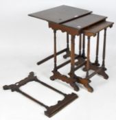 A nest of three tables, mahogany veneer with turned wooden supports and shaped legs,