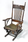 An antique oak rocking chair, the carved frames containing turned spindles and supports,