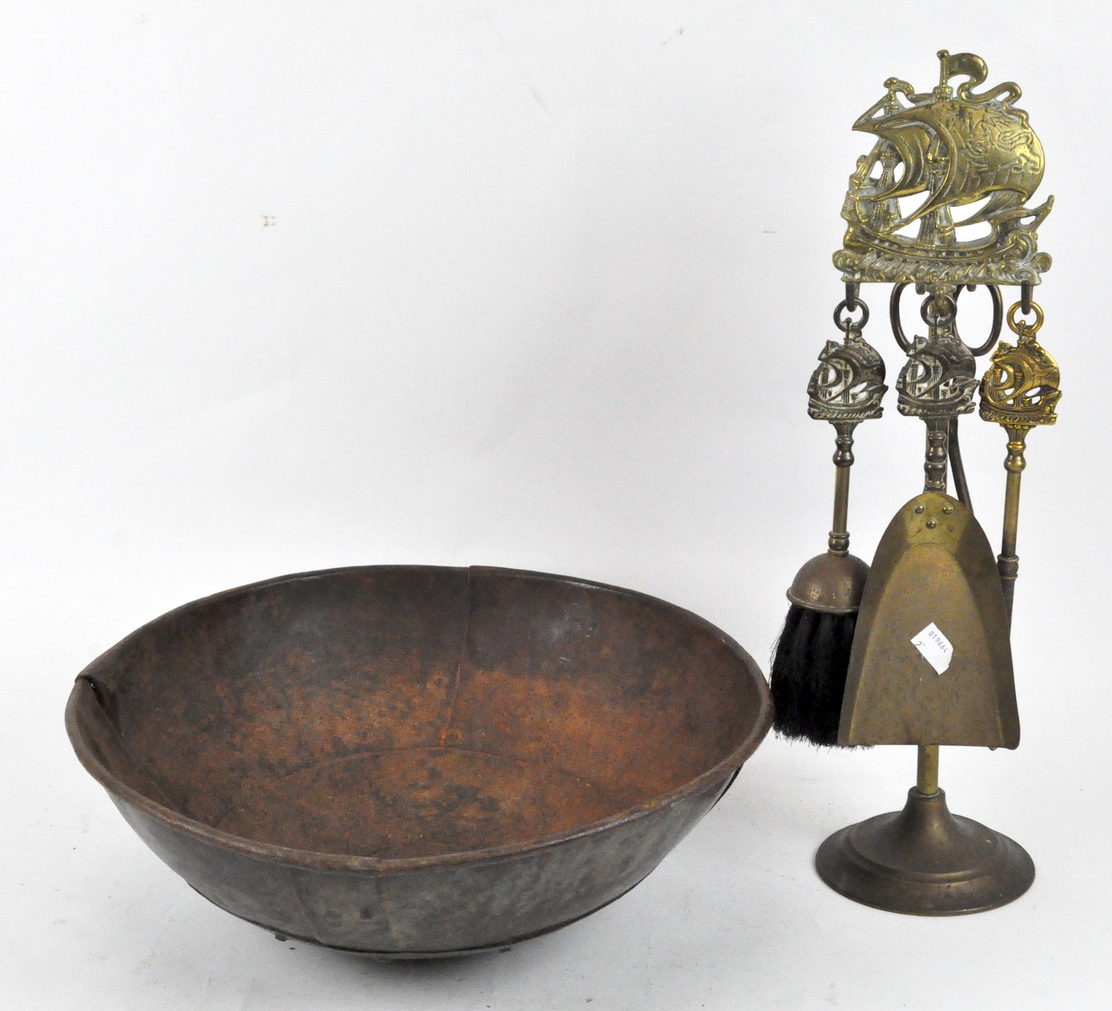 A brass fire companion set, the tops of the hold decorated with a sailing ship,