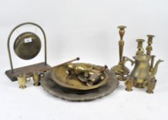 A large collection of brassware, including two pairs of candlesticks, a gong, cups,