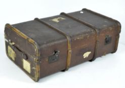 An early 20th century canvas travel trunk with wooden banding,