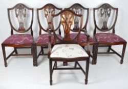 Five mahogany chairs to include a set of four with shield back with pierced splat carved with swags