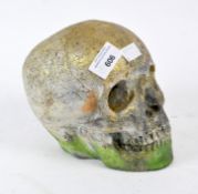 A novelty model of a skull, covered in gilt and green glitter,