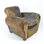 A vintage brown leather armchair, with a studded back and raised on square supports,
