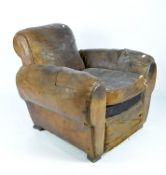 A vintage brown leather armchair, with a studded back and raised on square supports,