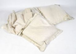 Three large cushions together with a cream tablecloth,