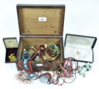 An assortment of vintage costume jewellery, in a mahogany storage box