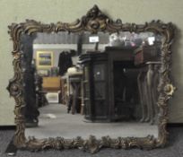 A gilt wall mirror, the wooden frame carved with flowers and foliage,