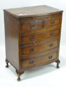 A 20th century veneered chest of drawers, comprising four long drawers,