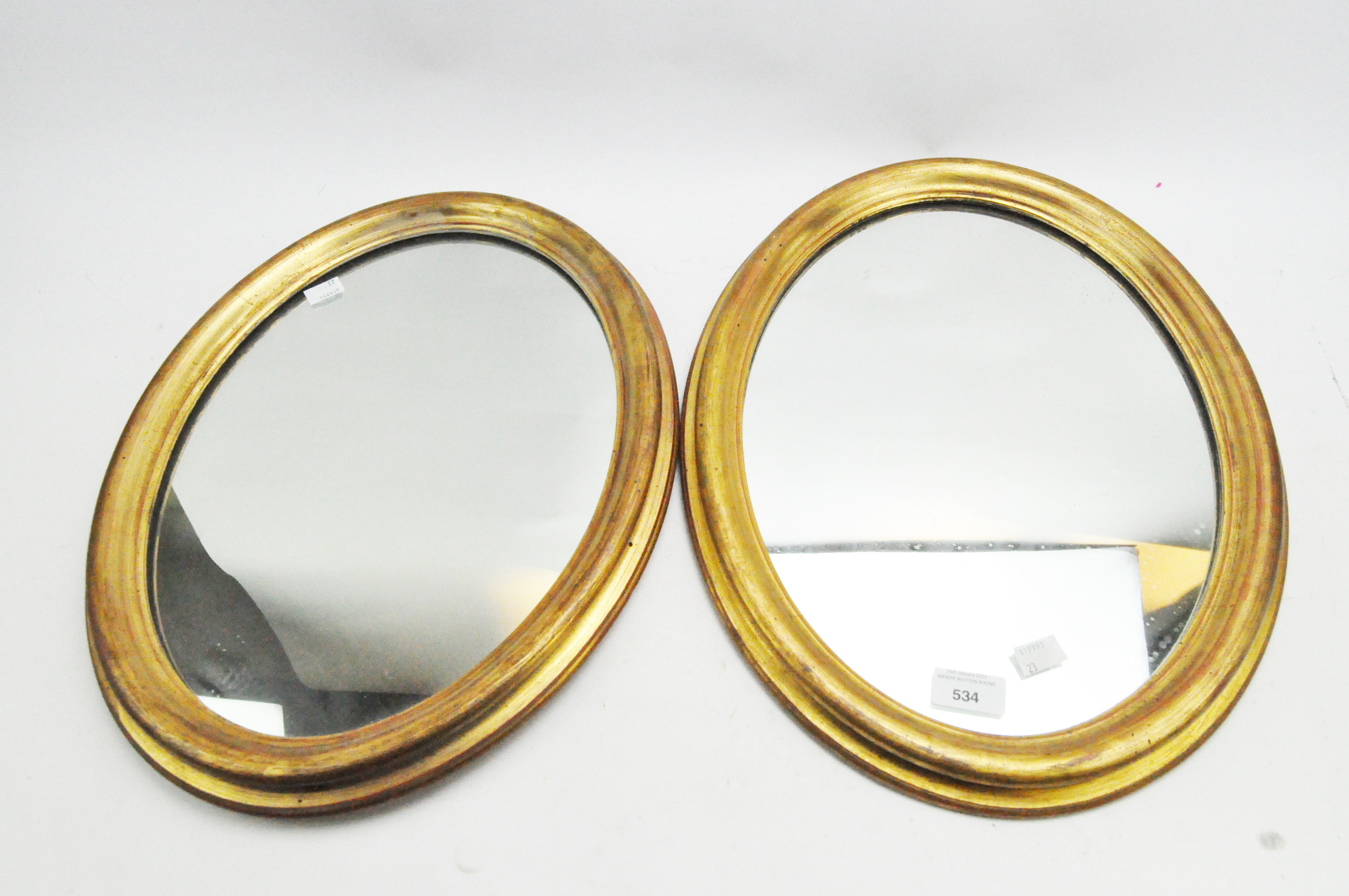 A pair of modern oval mirrors, in giltwood frames,