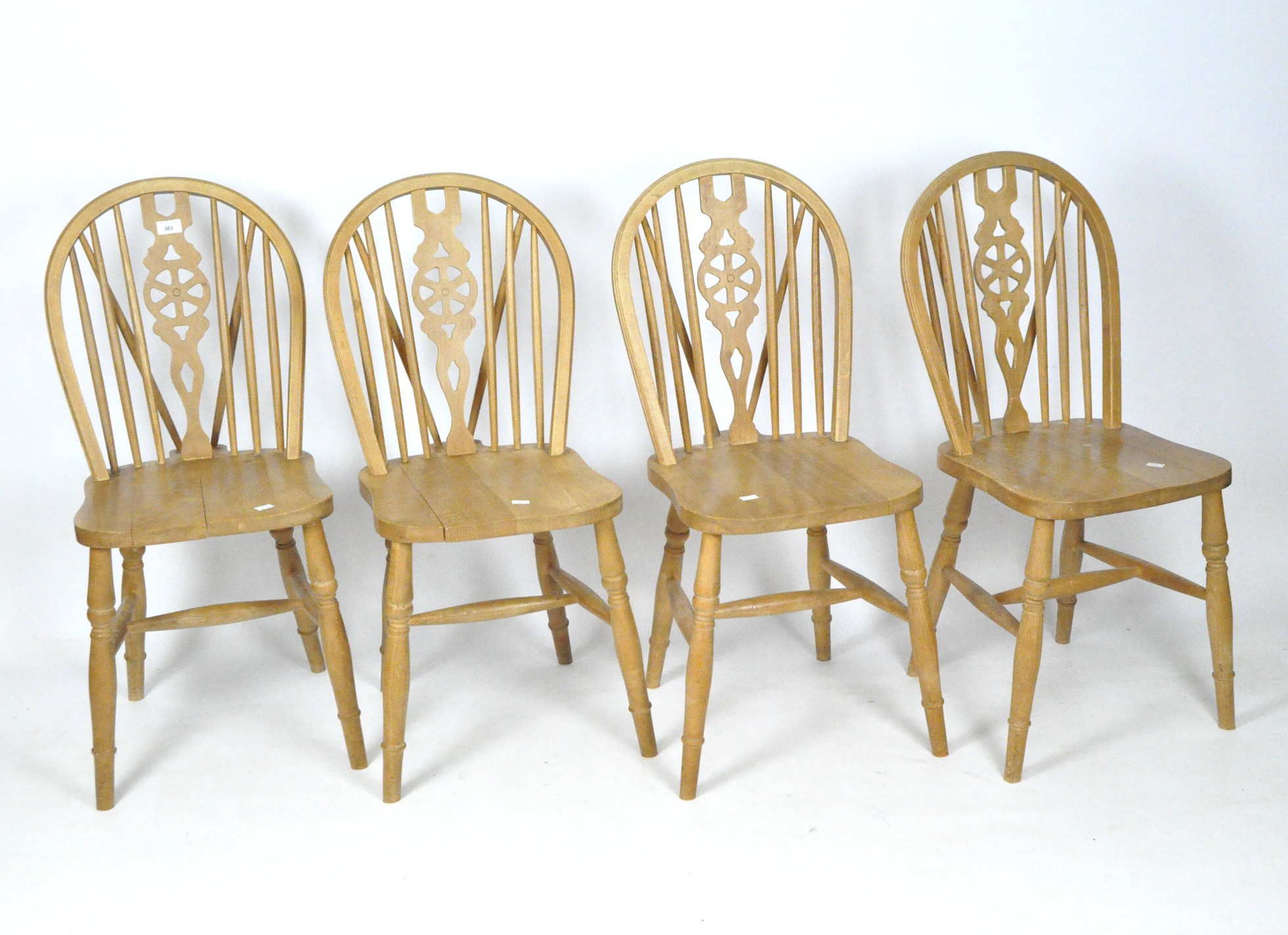 A set of four beech wheelback dining chairs,