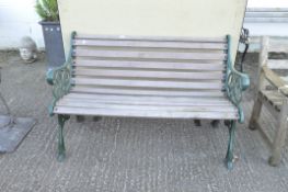 A silvered wood and green metal end garden bench,