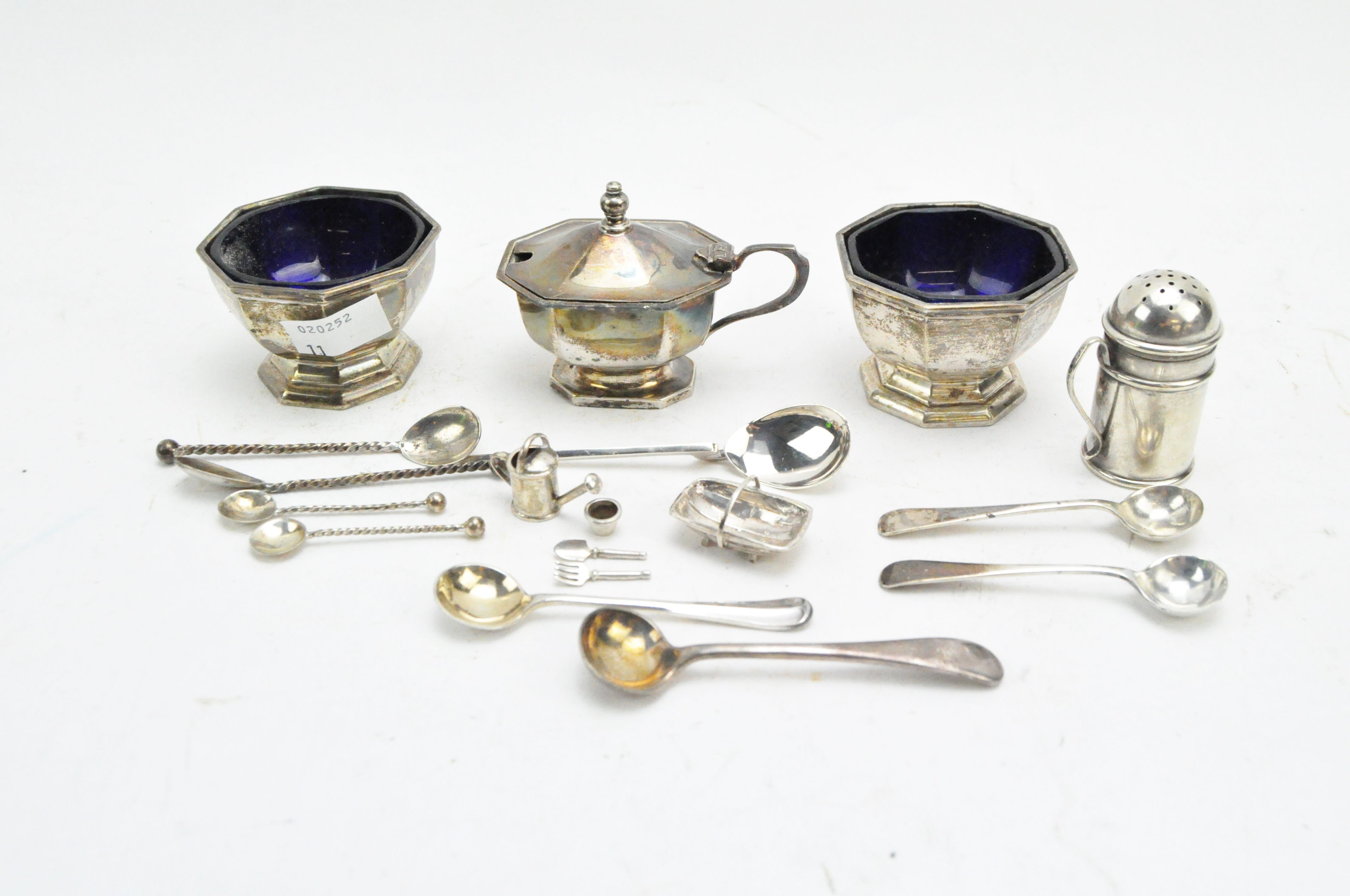 A collection of 19th & 20th century silver, including a condiment set, spoons, charms and more,