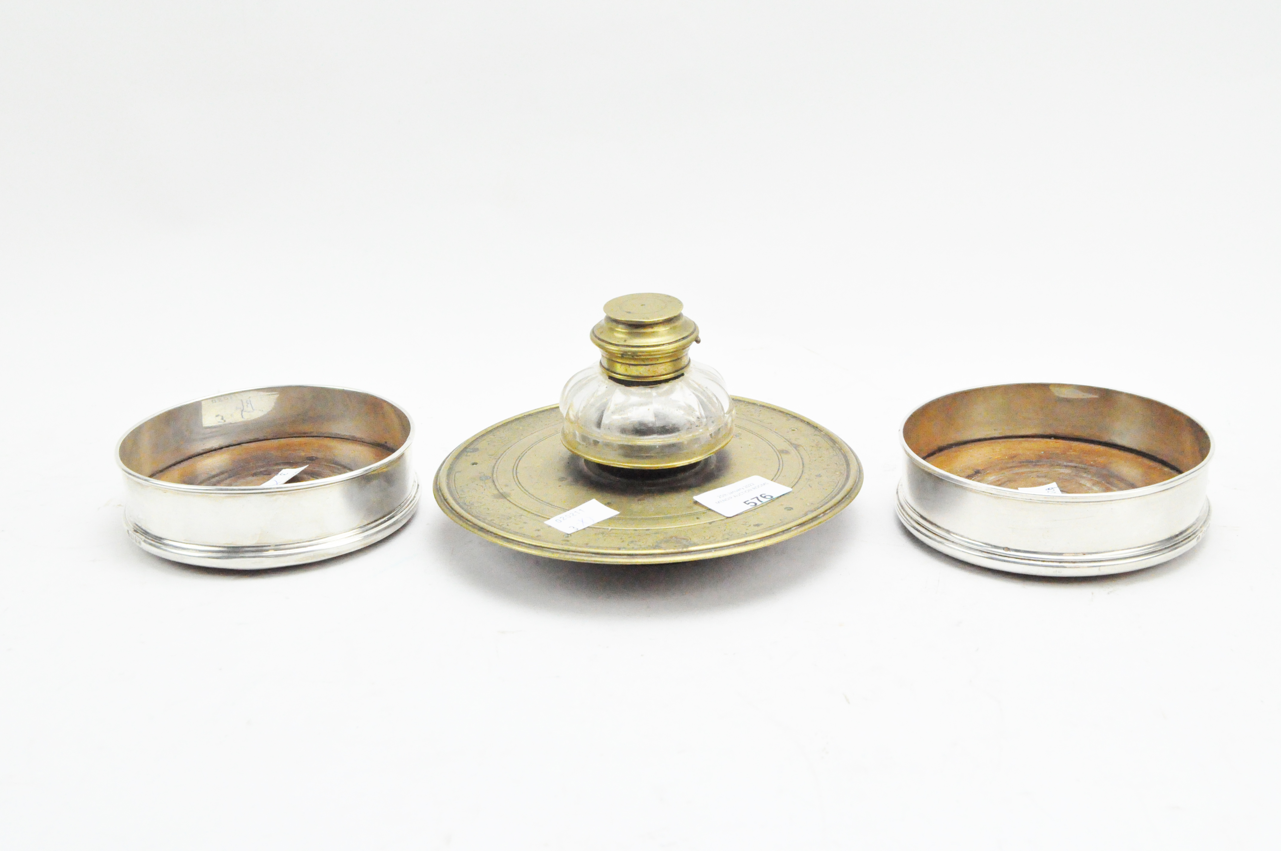 A pair of silver mounted wine coasters and a brass inkstand,