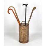 Four walking sticks and a wicker stand,