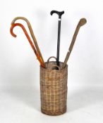 Four walking sticks and a wicker stand,