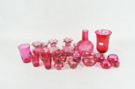 A collection of Victorian and Edwardian cranberry glass, including: a wrythen moulded bottle vase,