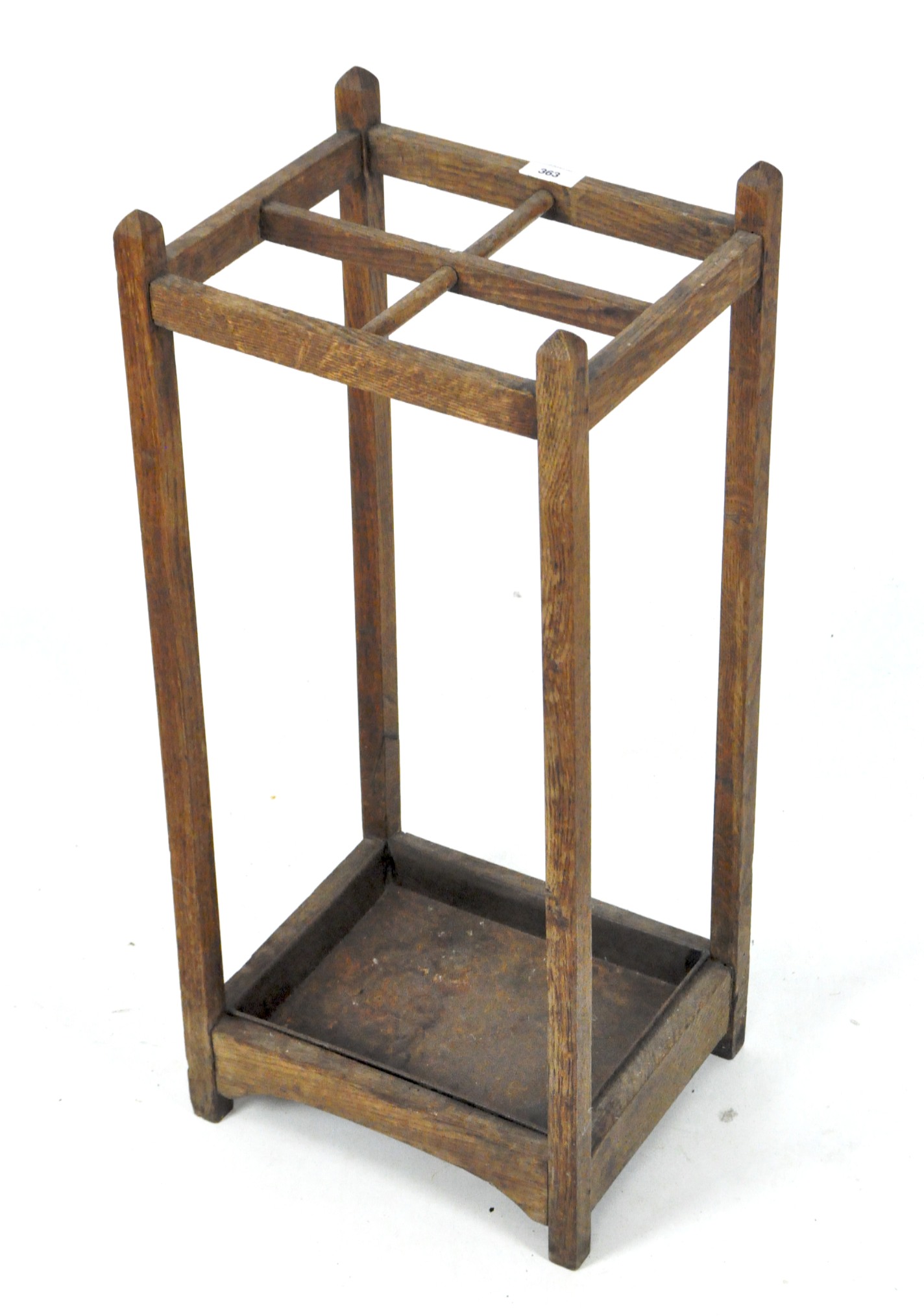 An early 20th century oak stick/umbrella stand, with four sectional top, metal tray to base,