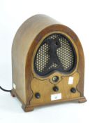 A vintage radio in stained wooden case with domed top,