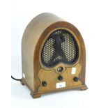 A vintage radio in stained wooden case with domed top,