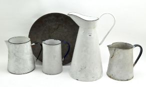 Four 20th century enamelled graduated jugs and pitchers and a charger