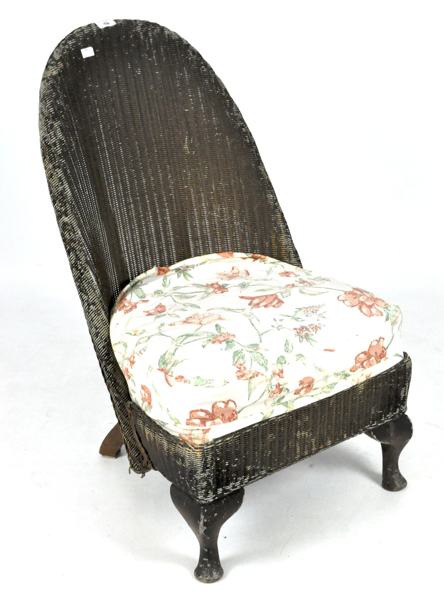 A vintage Lloyd Loom style nursing chair, raised upon front cabriole legs,