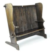 A 20th century elm settle, the panelled back of slight curving form,