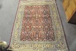 A 20th century Turkish rug, woven with dense flowers on a dark red ground,