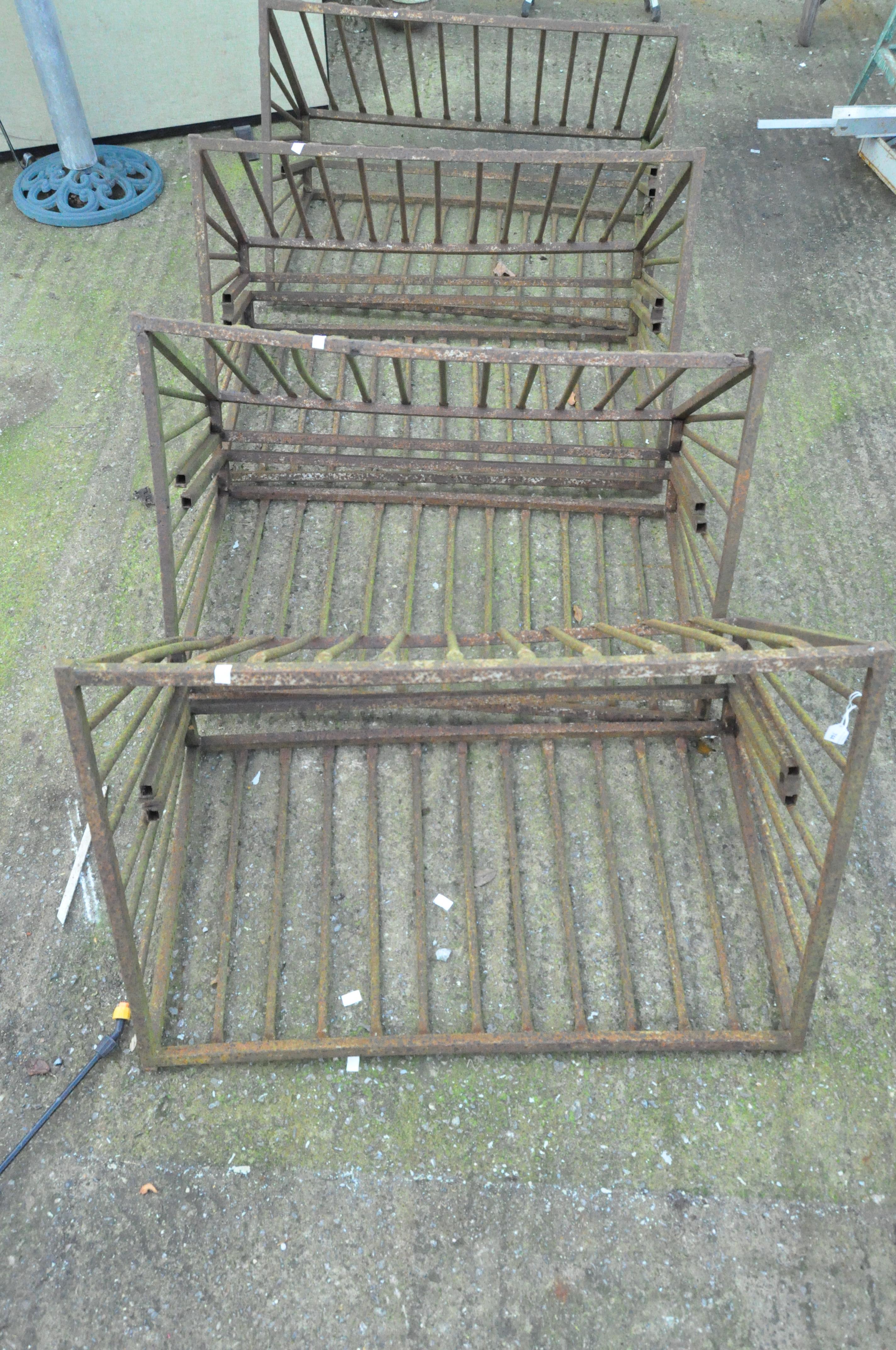 Four cast metal hay racks,