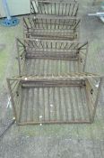 Four cast metal hay racks,