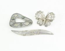 Three white metal and silver brooches, one designed as a filigree butterfly,