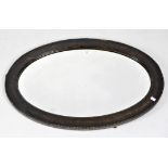 An oval oak framed wall mirror with bevelled glass plate. 85cm x 60cm.
