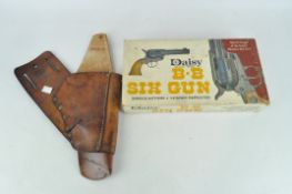 A six shot BB gun by Daisy in original box and a vintage leather gun holster