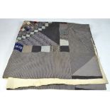 An early 20th century quilt, featuring patches and squares in a variety of colours,