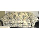 An early 20th century mahogany three seater sofa, with scroll arms and turned supports,