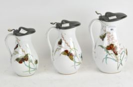 A set of three pewter topped jugs, of graduated sizes,
