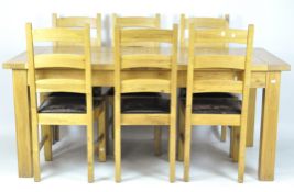 A contemporary oak dining table and six ladder back chairs,