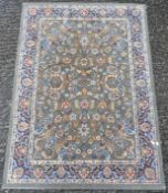 A 20th century woollen rug, decorated with flowers and foliage on a green ground,