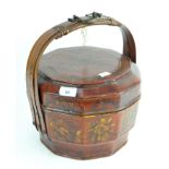 A vintage Chinese rice basket, in red lacquer and decorated with flowers,