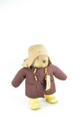 A vintage Paddington Bear, dressed in a characteristic felt hat, brown coat,