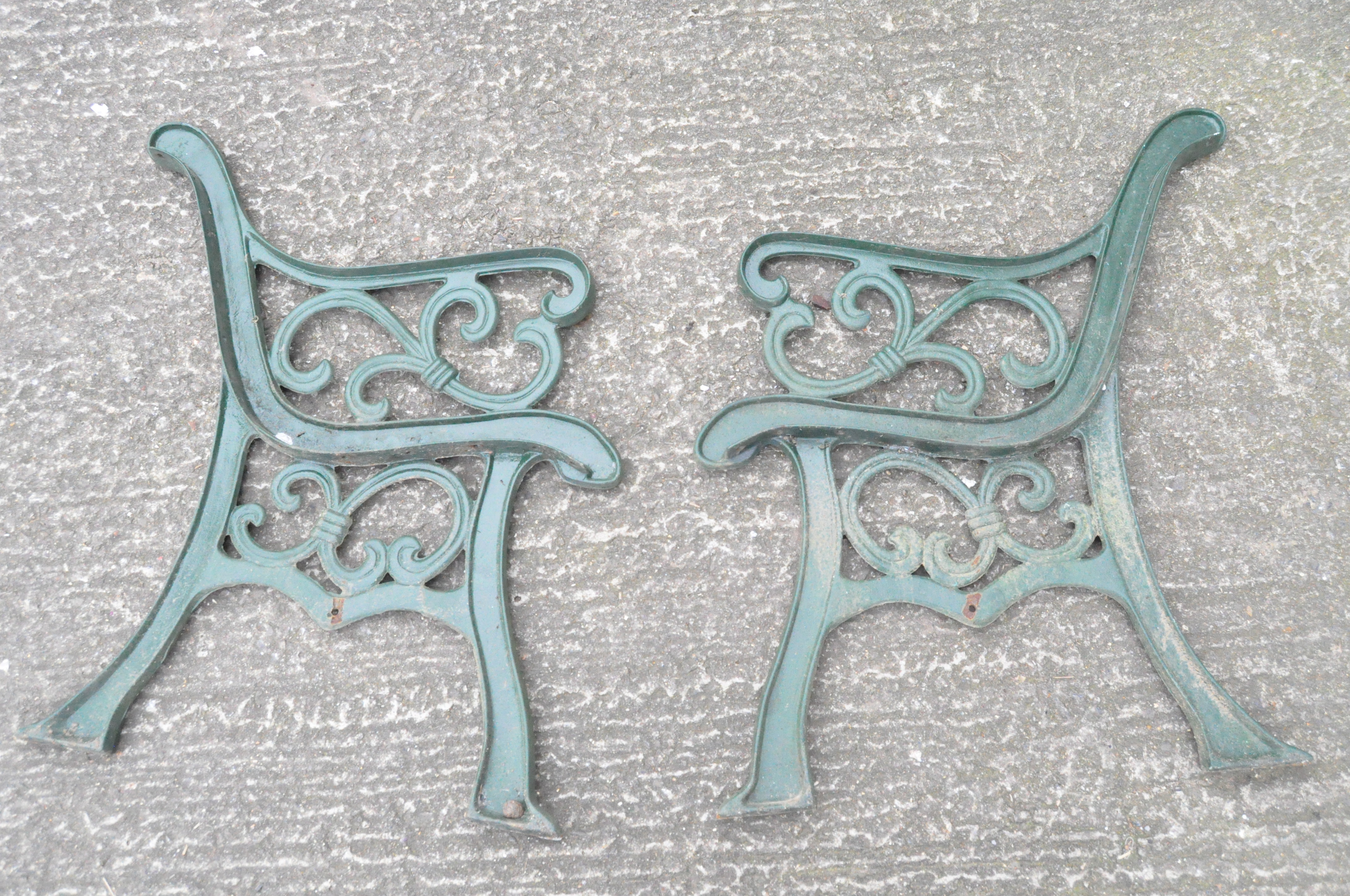 Pair of green painted metal bench ends,