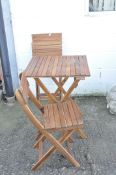 A modern folding wooden patio table and a pair of matching chairs,