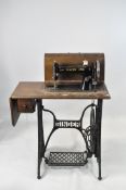 A vintage cased black and gilt Singer sewing machine, F621143, on the original base,