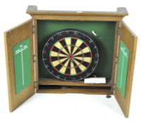 A wooden wall mounting unit containing a dart board,