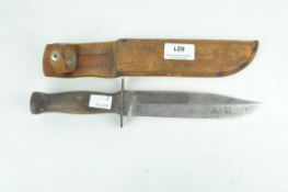 A Mexican bowie knife with a wooden handle, within a brown leather sheath,