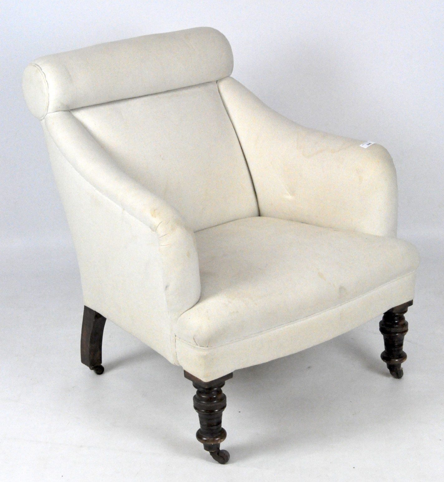 A Late Victorian/Edwardian armchair, upholstered in plain white fabric,